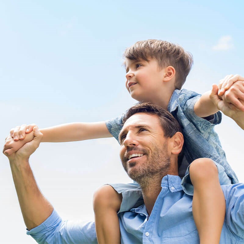 Dad with Son on shoulders outdoors
