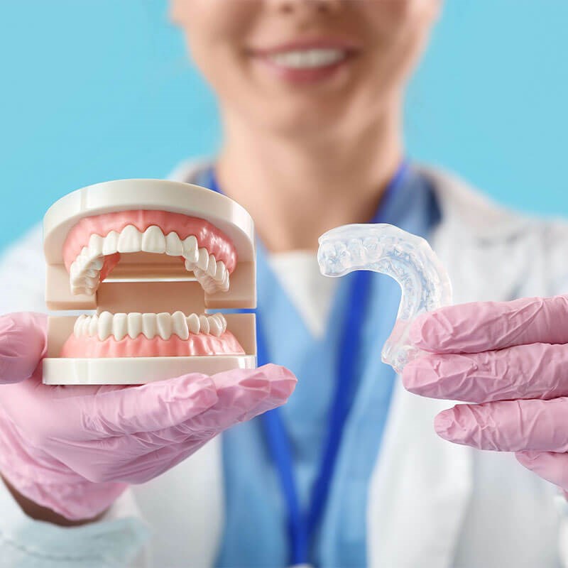 Orthodontist holding aligners and teeth diagram