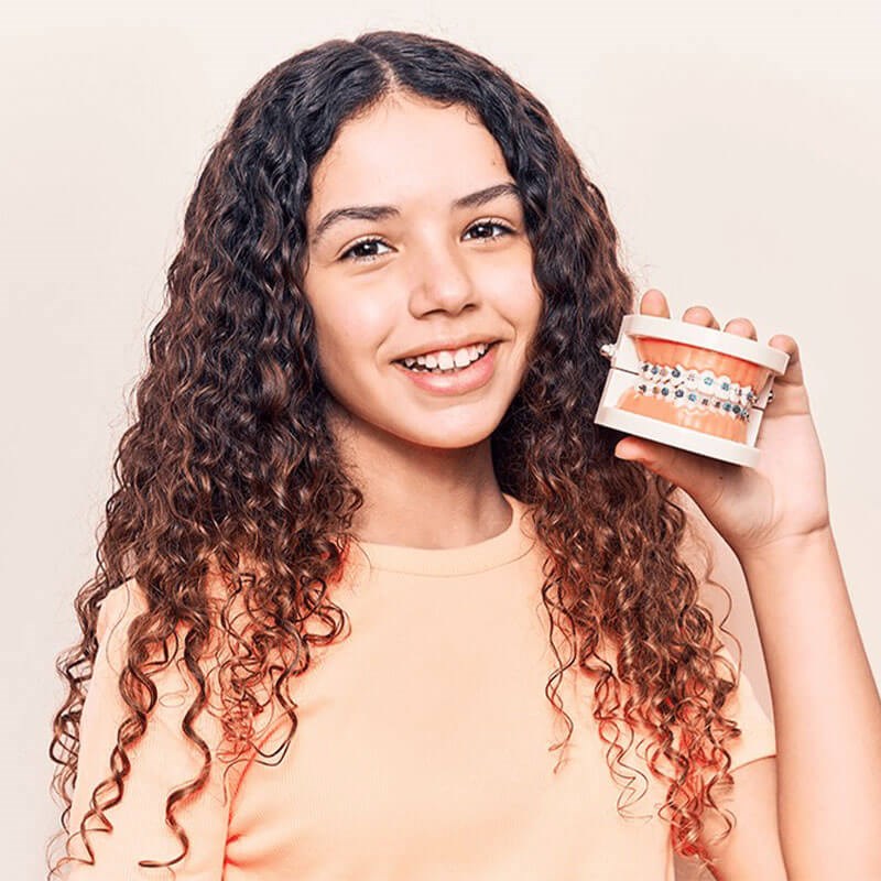 Teenager smiling while holding teeth